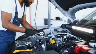 Technician working in a vehicle engine bay